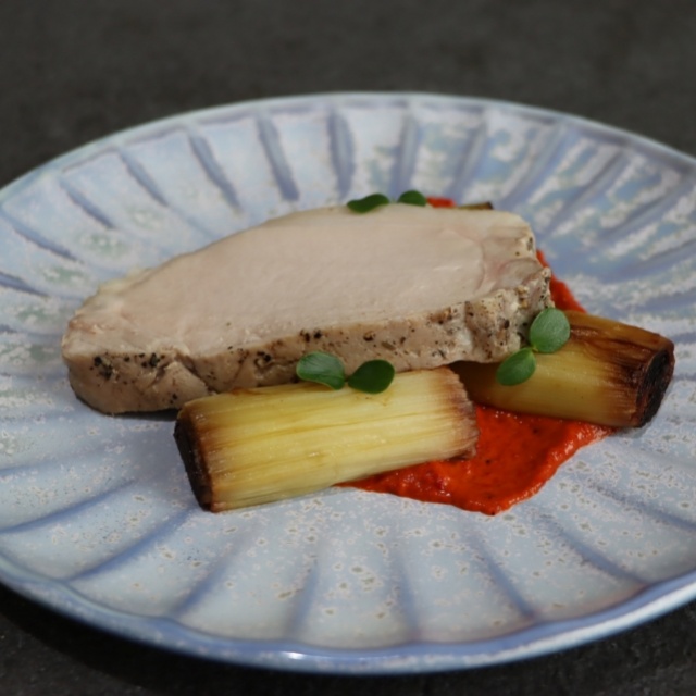 In kruidenolie gegaarde kalfsmedaillon, puree van geroosterde paprika en geblakerde prei